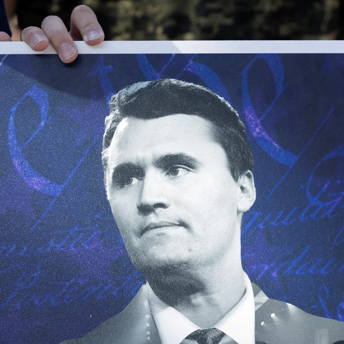 FILE PHOTO: An attendee holds a poster of conservative activist Charlie Kirk as people mourn following his fatal shooting, at the University of Houston in Houston, Texas, U.S., September 11, 2025. REUTERS/Antranik Tavitian/File Photo