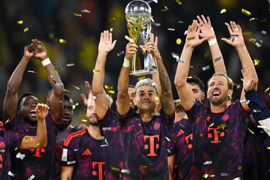 Soccer Football - DFL Supercup - Final - Borussia Dortmund v Bayern Munich - Signal Iduna Park, Dortmund, Germany - August 22, 2026  Bayern Munich's Luis Diaz lifts the trophy with Harry Kane and teammates after winning the DFL Supercup final REUTERS/Teresa Kroeger