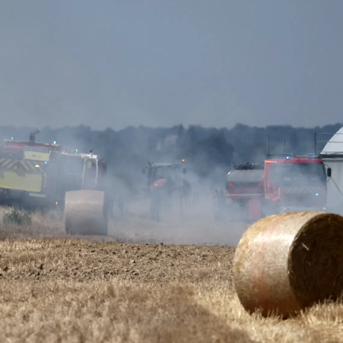 FILE PHOTO: French firefighters work to extinguish burning haystacks in a field at a farm near Loretz-d'Argenton, in the Deux-Sevres department, during a heatwave affecting a majority of the country, France, June 25, 2026.  REUTERS/Stephane Mahe/File Photo