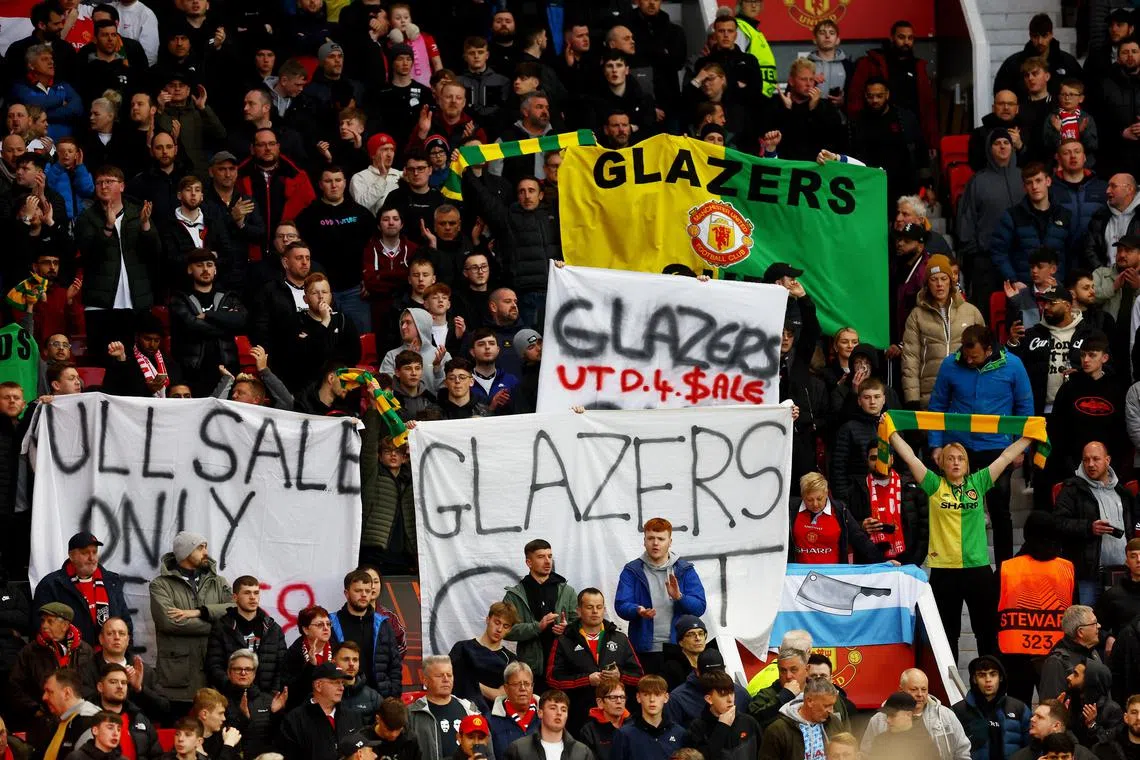 Manchester United fans display banners in protest of the Glazer family’s ownership of the club.