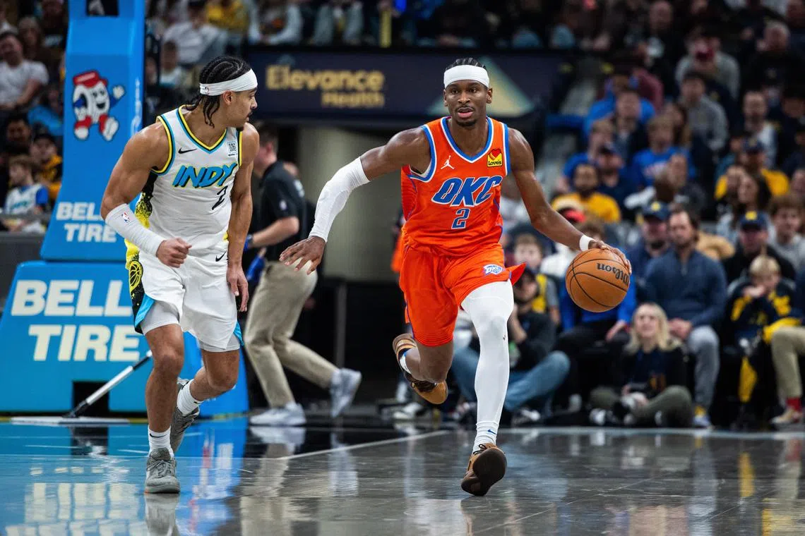 Oklahoma City Thunder guard Shai Gilgeous-Alexander dribbles the ball while  Indiana Pacers guard Andrew Nembhard defends in the second half at Gainbridge Fieldhouse. 