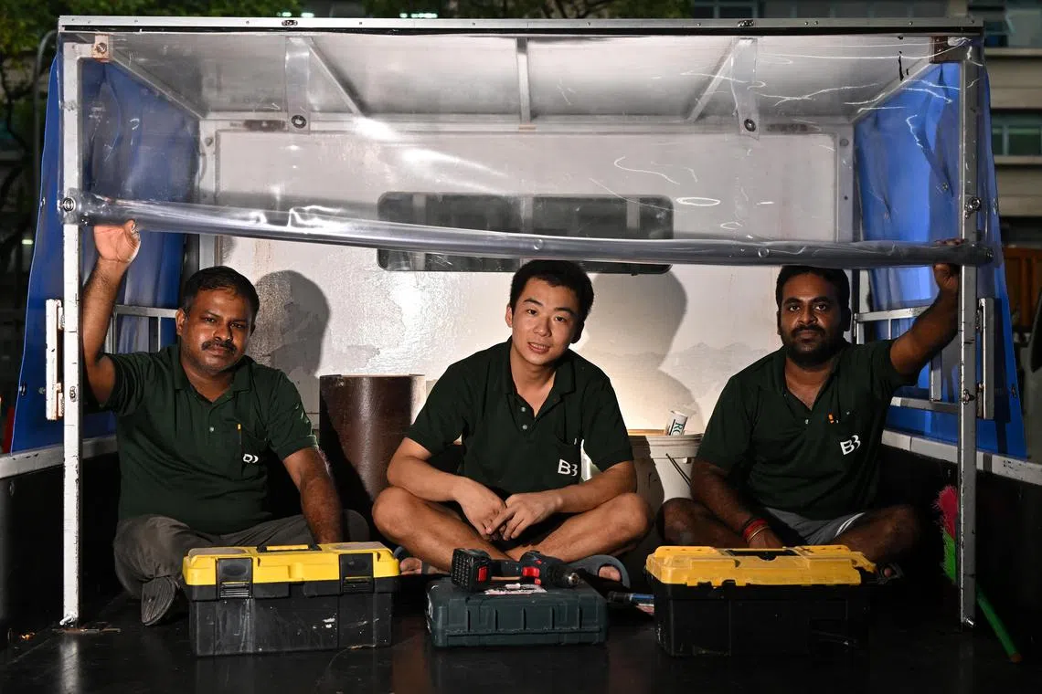 (From left) Mr Thangam Gunaseelean, 40, Mr Li Jia Ming, 25, and Mr Ramalingam Selva Kumar, 32, all carpenters, posing under the shelter at the back of the company's truck at Hiangkie Industrial Building on Oct 18, 2023.
Migrant workers on the backs for trucks and having lunch on the floors of HDB void decks have been the subject of much debate in the press and over social media. Three design houses have come together to propose design hacks to make life easier for migrant workers through special seating on flatbed trucks and tentage for privacy during lunch breaks.
(ST PHOTO: LIM YAOHUI)