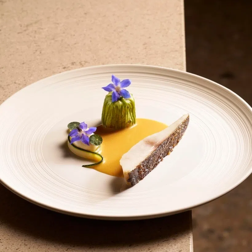 Grilled isaki, or Japanese grunt fish, is served with a beurre blanc sauce infused with Peranakan flavours (left). A tomatillo salsa adds gentle tartness to a course of vegetable dumpling with soya milk foam.