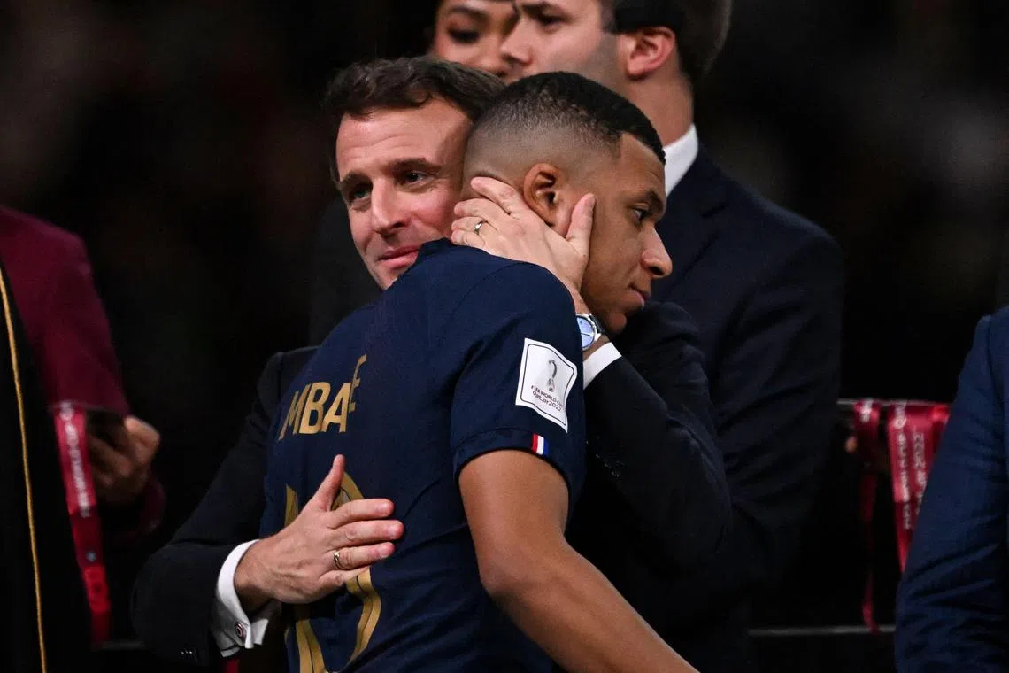France's forward #10 Kylian Mbappe is consoled by French President Emmanuel Macron after France lost.
