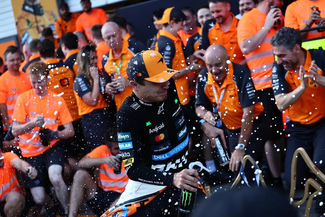 McLaren driver Lando Norris celebrates with the team after a one-two finish in the Formula 1 Austrian Grand Prix.
