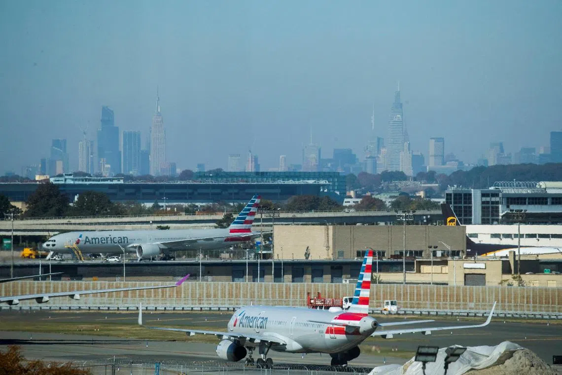 An American Airlines planes taxi on the tarmac as the skyline of New York City is seen in the background from the JFK International Airport in New York. 
