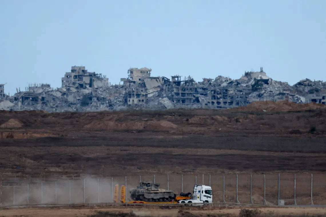 A truck transports an Israeli armoured personnel carrier (APC) near the Israel-Gaza border, after a ceasefire between Israel and Hamas in Gaza went into effect, in Israel, October 10, 2025. REUTERS/Shir Torem