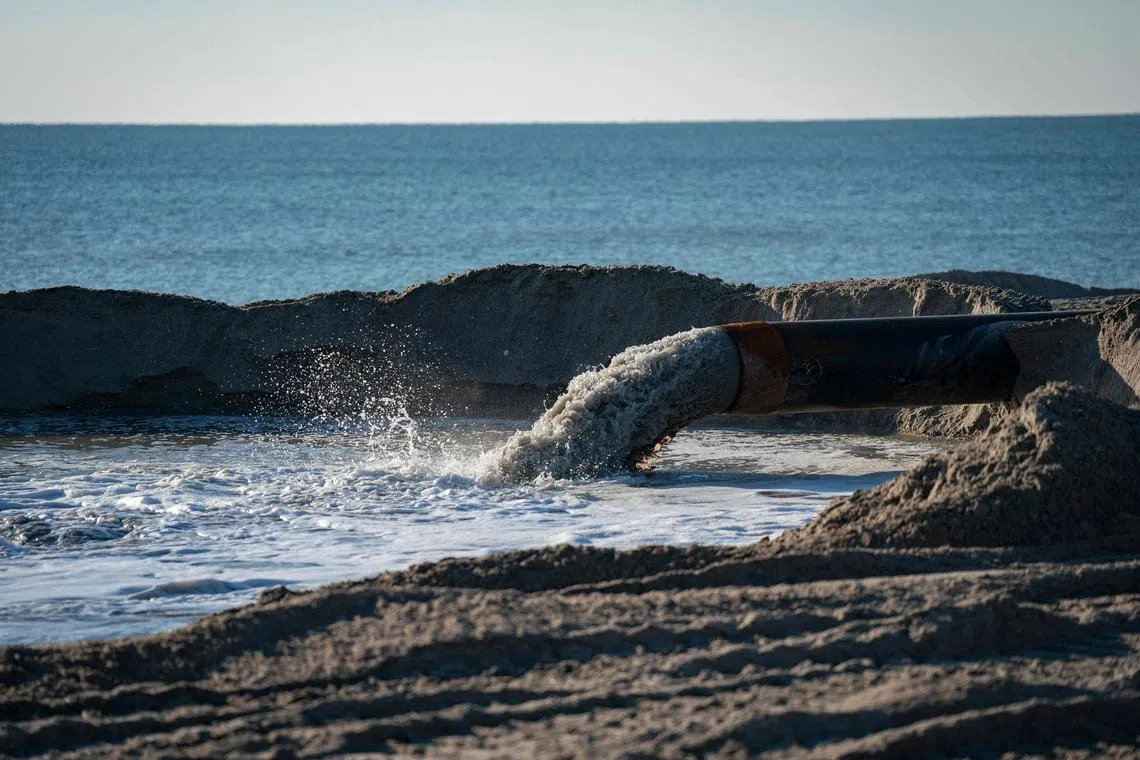 WRIGHTSVILLE BEACH, NORTH CAROLINA - JANUARY 20: Sand is moved onto the beach during a nourishment project on January 20, 2024 in Wrightsville Beach, North Carolina. Beach nourishment, or beach filling, is the practice of adding large quantities of sand or sediment to beaches to combat erosion and increase beach width. As global sea levels rise due to man-made climate change, extensive coastal erosion is a problem that coasts around the United States are facing. Already, coastal erosion costs roughly $500 million per year for property loss, including damage to structures and loss of land.   Allison Joyce/Getty Images/AFP (Photo by Allison Joyce / GETTY IMAGES NORTH AMERICA / Getty Images via AFP)