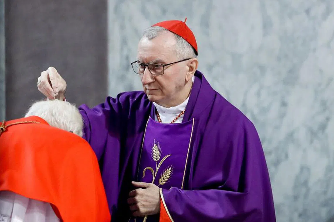 FILE PHOTO: Vatican Secretary of State Cardinal Pietro Parolin puts ashes on a cardinal's head during a mass on Ash Wednesday in Rome, Italy, March 2, 2022. REUTERS/Remo Casilli/File Photo