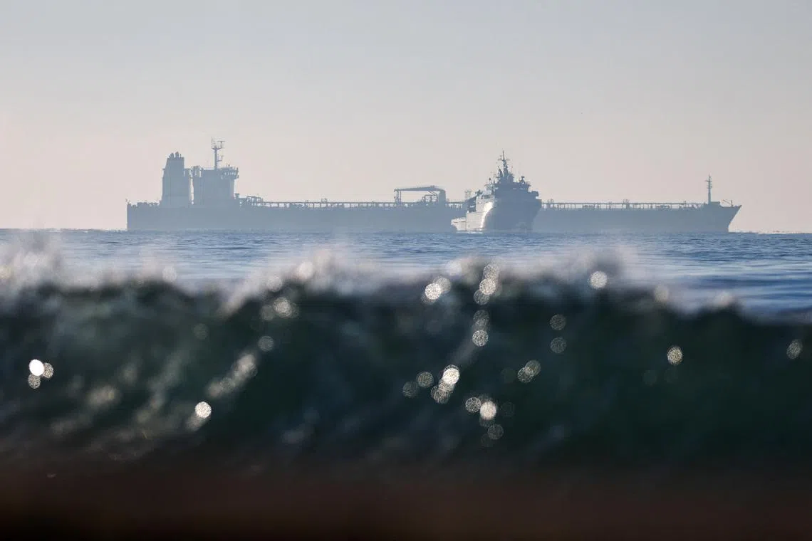 The silhouette of a French navy boat surrounding the GRINCH oil tanker, intercepted by France in the Alboran Sea on suspicion of operating under a false flag and belonging to Russia's shadow fleet that enables Russia to export oil despite sanctions, and diverted to the port of Marseille-Fos, in the Gulf of Fos-sur-Mer, near Martigues, France, January 25, 2026. REUTERS/Manon Cruz