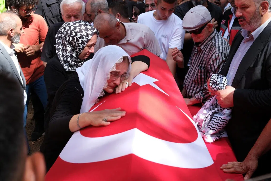 A relative of Aysenur Ezgi Eygi, a Turkish-American activist killed in the Israeli-occupied West Bank, mourns over her Turkish flag-draped coffin during the funeral ceremony at a cemetery in Didim, in the western Aydin province, Turkey, September 14, 2024. REUTERS/Murat Kocabas/File Photo