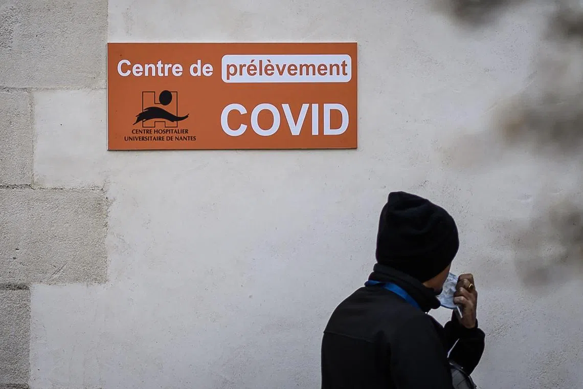 A man passes in front of a Covid 19 laboratory in Nantes, western France, on Jan 11, 2023.