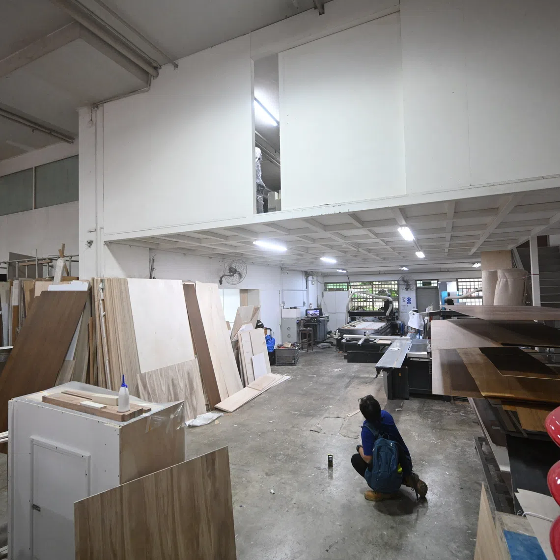 An MOM officer measuring the height of a workshop's mezzanine at a worksite in Ubi during a surprise inspection on Nov 21.