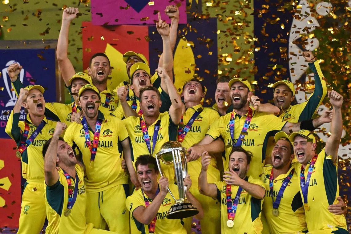 Australia's players celebrate with the trophy after winning the 2023 ICC Men's Cricket World Cup one-day international final match.