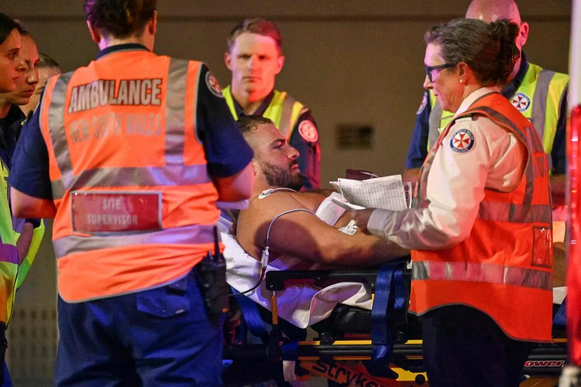 Health workers move a man on a stretcher to an ambulance after a shooting incident at Bondi Beach in Sydney on Dec 14, 2025.  