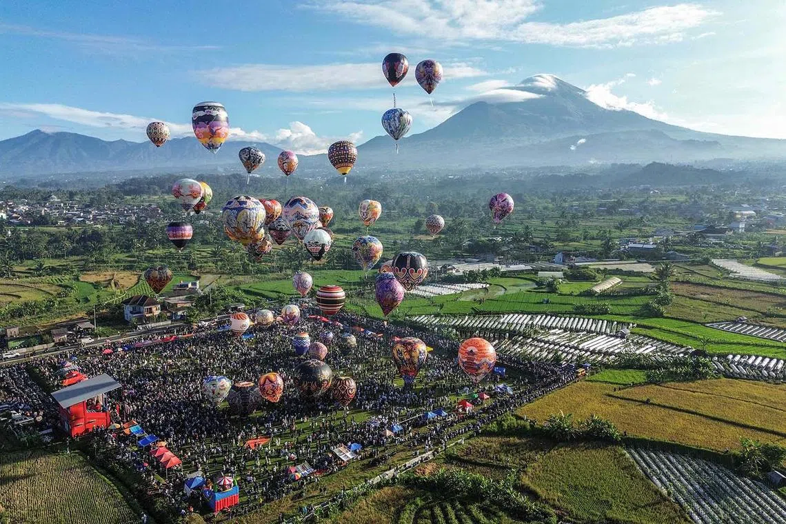 An aerial image showing hot air balloons, mostly made from recycled paper and tied with ropes, floating in the air during the annual hot air balloon festival in Wonosobo, Central Java, Indonesia, on April 2, 2025, held to celebrate Eid al-Fitr. 