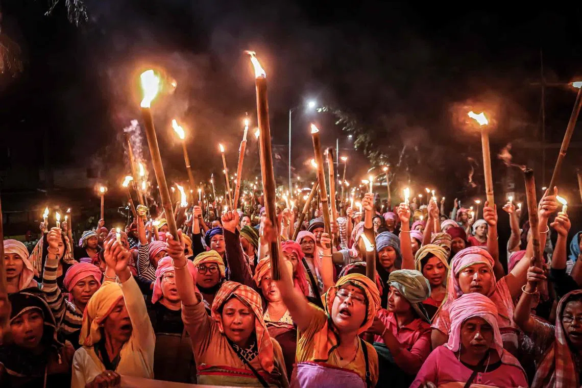 Women hold torches during a demonstration demanding the restoration of peace in India's north-eastern Manipur state following ethnic violence.