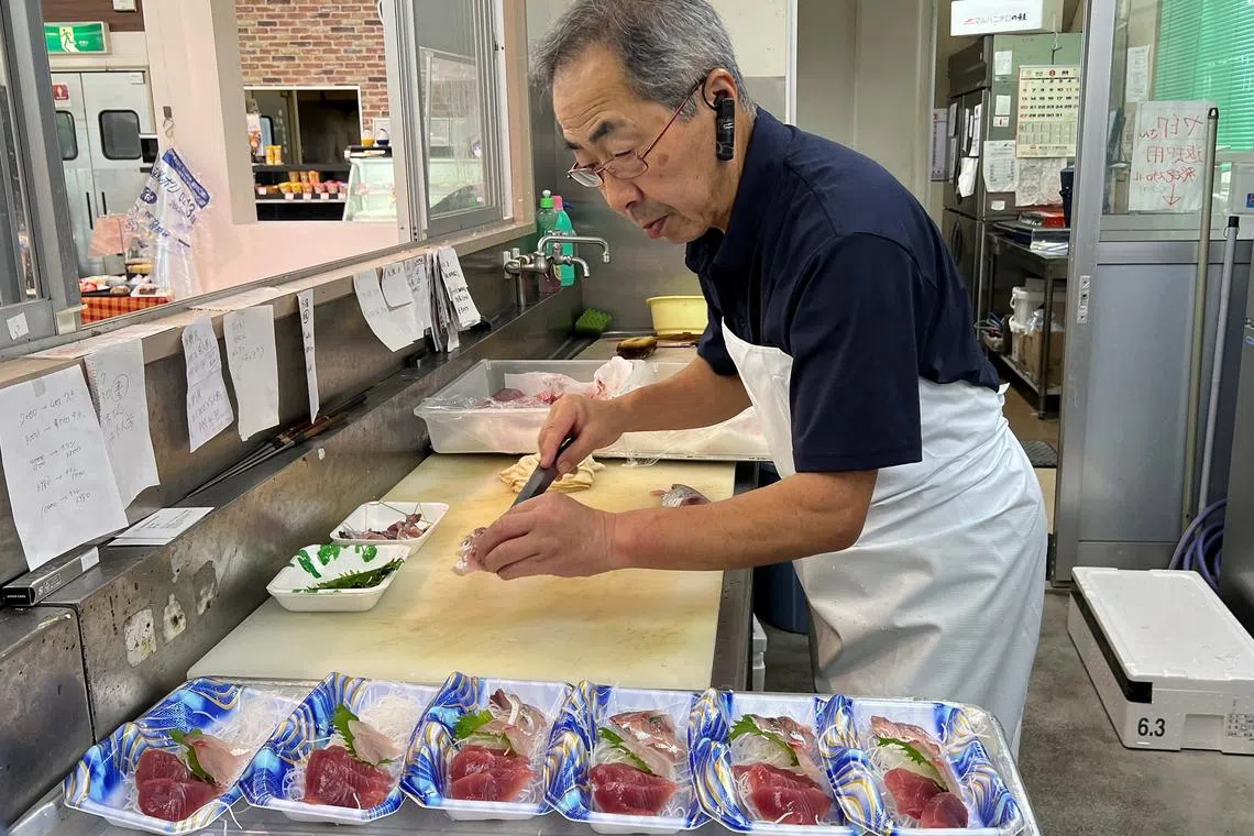 Supermarket owner Takashi Nakajima, 67, prepares sashimi to sell at his store, near the Fukushima Daiichi nuclear power plant, on Aug 9, 2023.