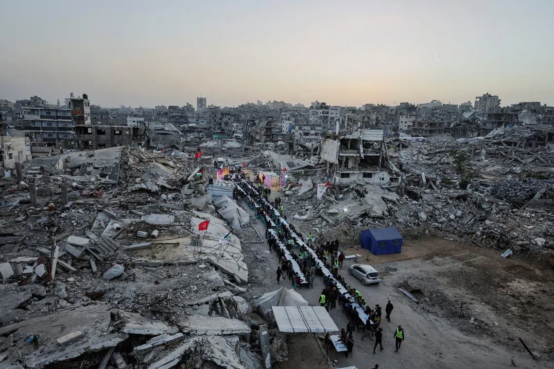 FILE PHOTO: Palestinians gather to break their fast by eating Iftar meals on the first day of the holy month of Ramadan, near the rubble of residential buildings destroyed during the two-year Israeli offensive, in Gaza City, February 18, 2026. REUTERS/Dawoud Abu Alkas/File Photo