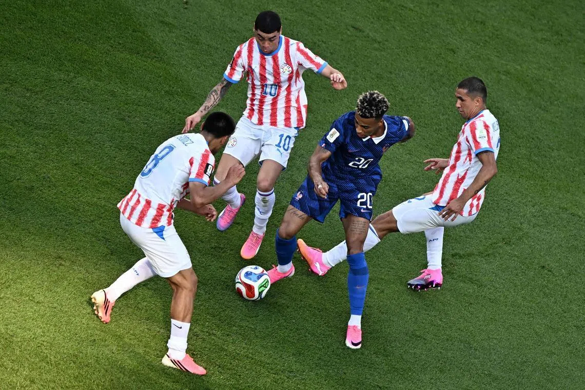 France’s Desire Doue weaving through a trio of Paraguay defenders, which ultimately led to him being tripped by Diego Gomez (left) and earning a penalty that striker Kylian Mbappe duly converted as Les Bleus won the World Cup last-16 clash 1-0.