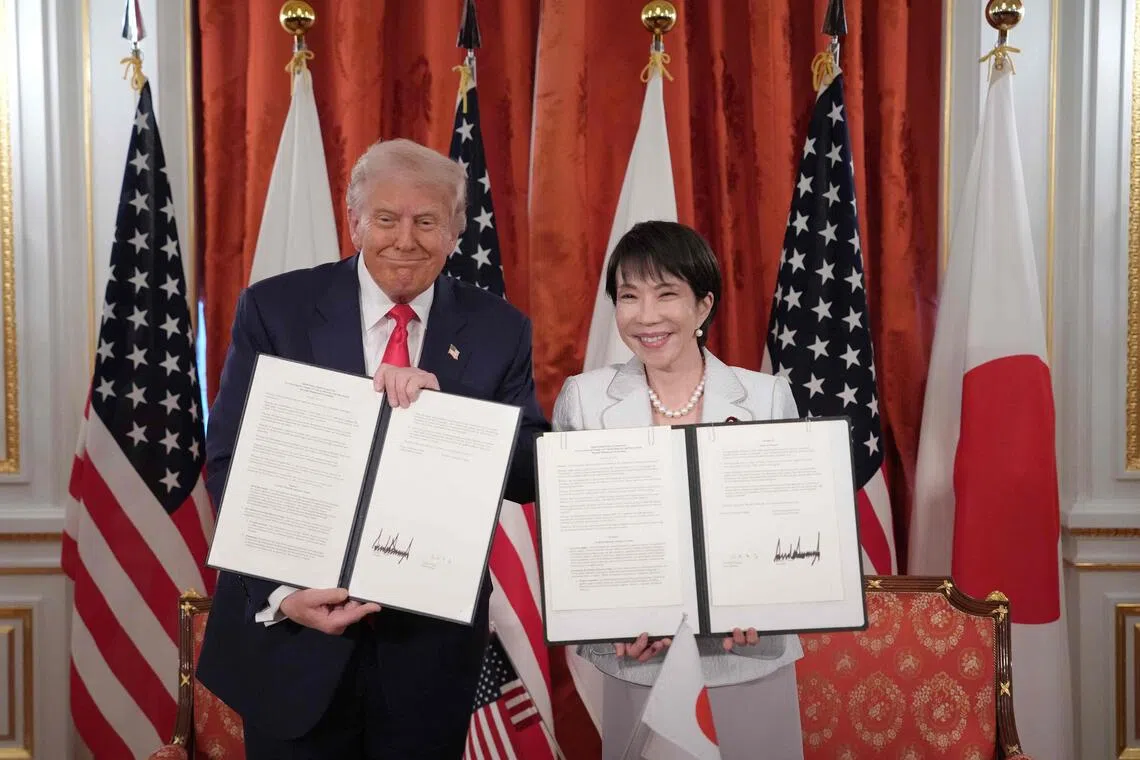 US President Donald Trump (left) and Japanese Prime Minister Sanae Takaichi (right) hold up signed documents for a critical minerals/rare earth deal during a meeting at Akasaka Palace on Oct 28, 2025 in Tokyo, Japan.  