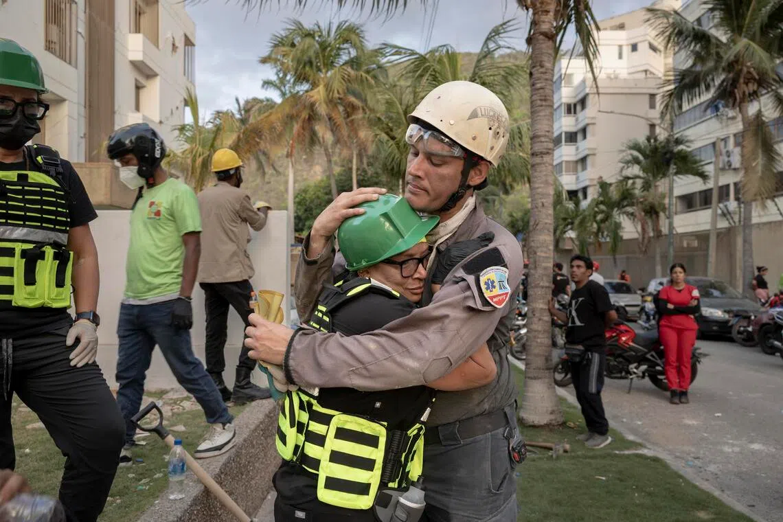 Returning to the building where she lived, Dr. Zaira Medina, left, embraces a member of the rescue team who informed her that no survivors have been found, in La Guaira, Venezuela, two days after the earthquakes, on Friday, June 26, 2026. Rescuers worked under floodlights early Saturday in the desperate effort to find survivors, as the death toll rose to 920 and thousands of injured people overwhelmed hospitals. (Fabiola Ferrero/The New York Times)