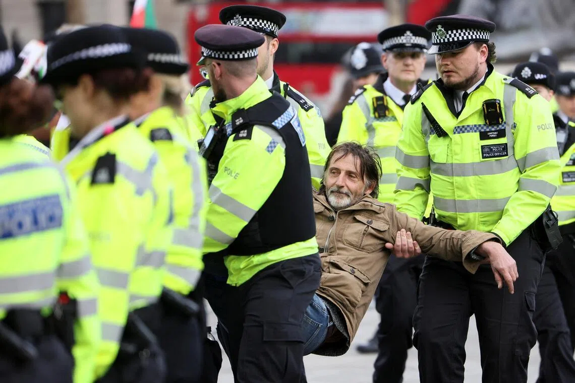 Police officers detaining a protester in London's Trafalgar Square on April 11. 