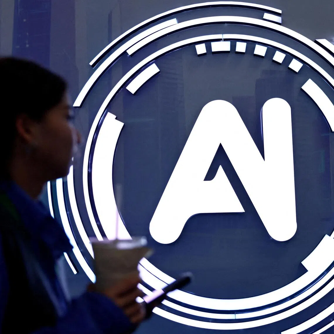 A woman walks past a sign of AI at the expo of the World Internet Conference in Wuzhen town of Tongxiang city, Zhejiang province, China on Nov 8, 2025. 