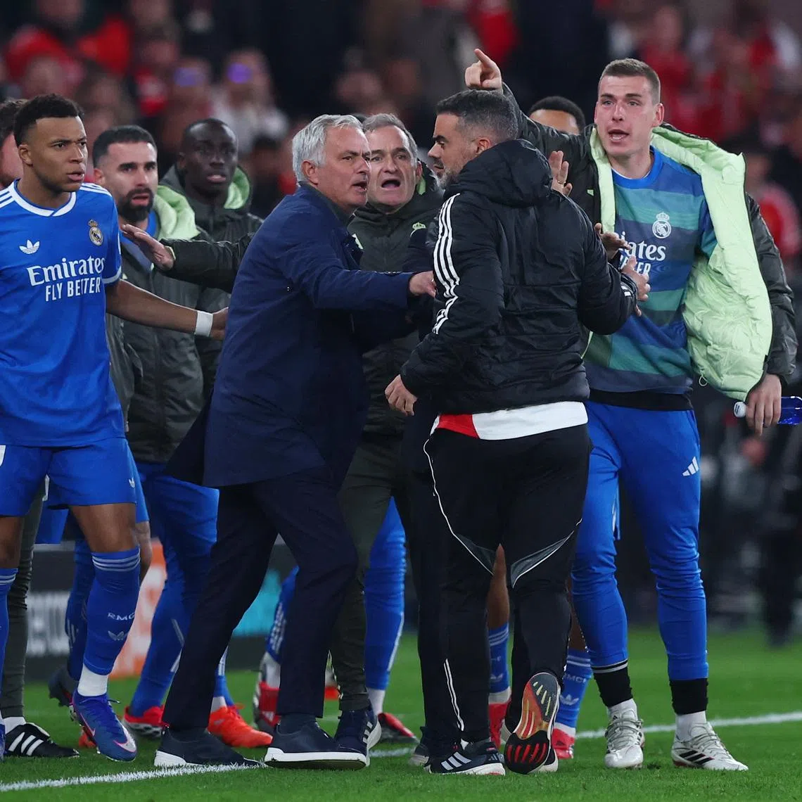 Soccer Football - UEFA Champions League - Play Off - First Leg - Benfica v Real Madrid - Estadio da Luz, Lisbon, Portugal - February 17, 2026 Real Madrid's Kylian Mbappe with Benfica coach Jose Mourinho as the match was stopped due to racist chants REUTERS/Pedro Nunes
