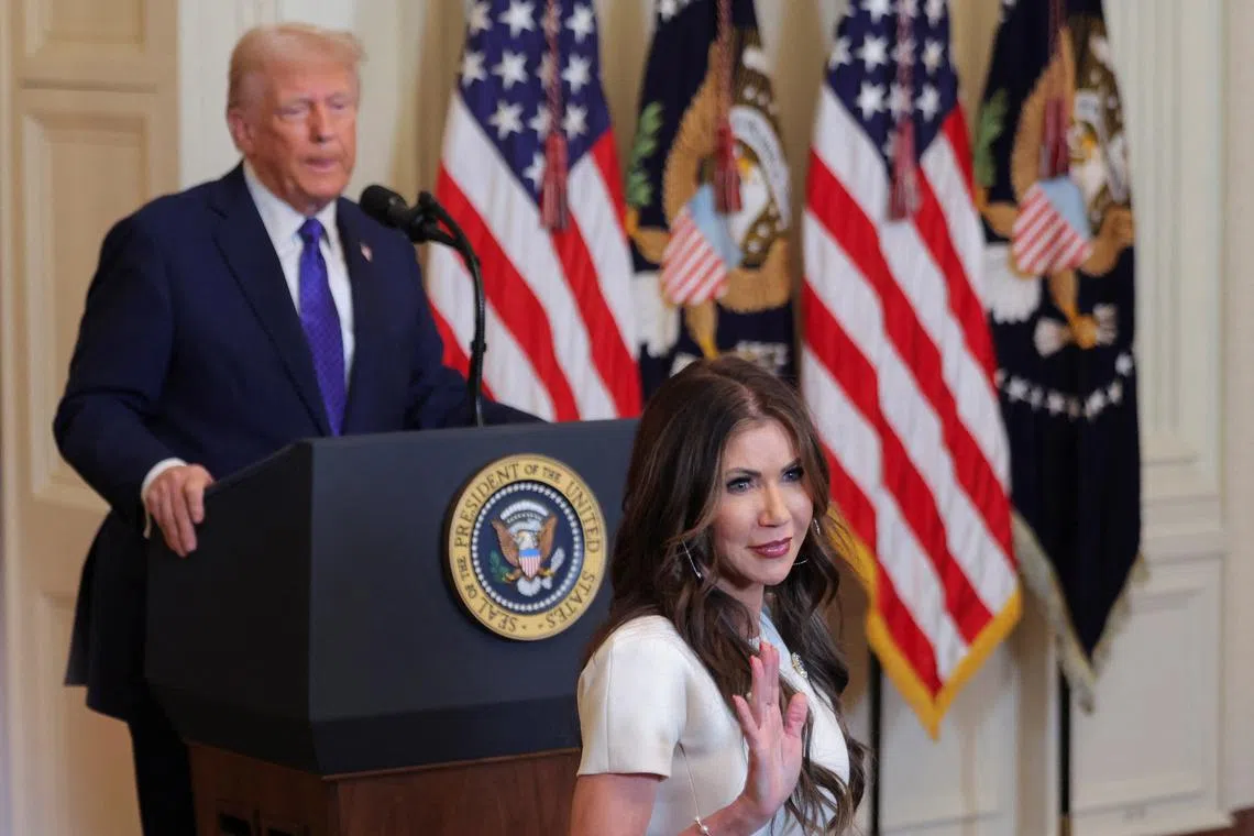FILE PHOTO: Homeland Security Secretary Kristi Noem waves as U.S. President Donald Trump speaks during the signing event for the Laken Riley Act at the White House in Washington, U.S.,  January 29, 2025. REUTERS/Carlos Barria/File Photo