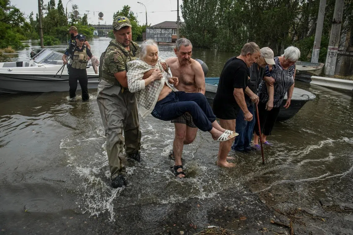 Rescuers evacuate local residents from a flooded area in Kherson, Ukraine.