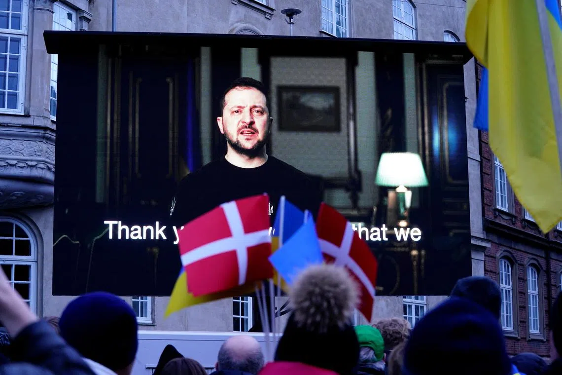 Ukrainian President Volodymyr Zelensky (onscreen) addresses a demonstration in Copenhagen against Russia's war in Ukraine, on Feb 24, 2023.