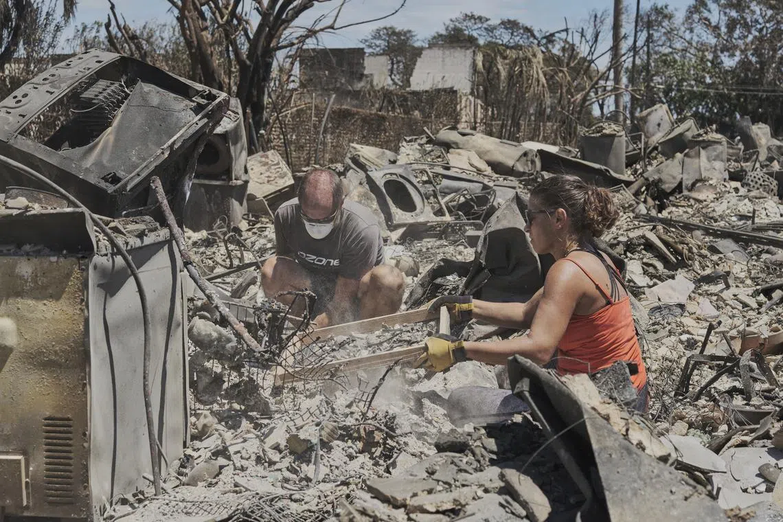 A couple searches for belongings at their destroyed apartment in Lahaina, Hawaii, on Aug 11, 2023.