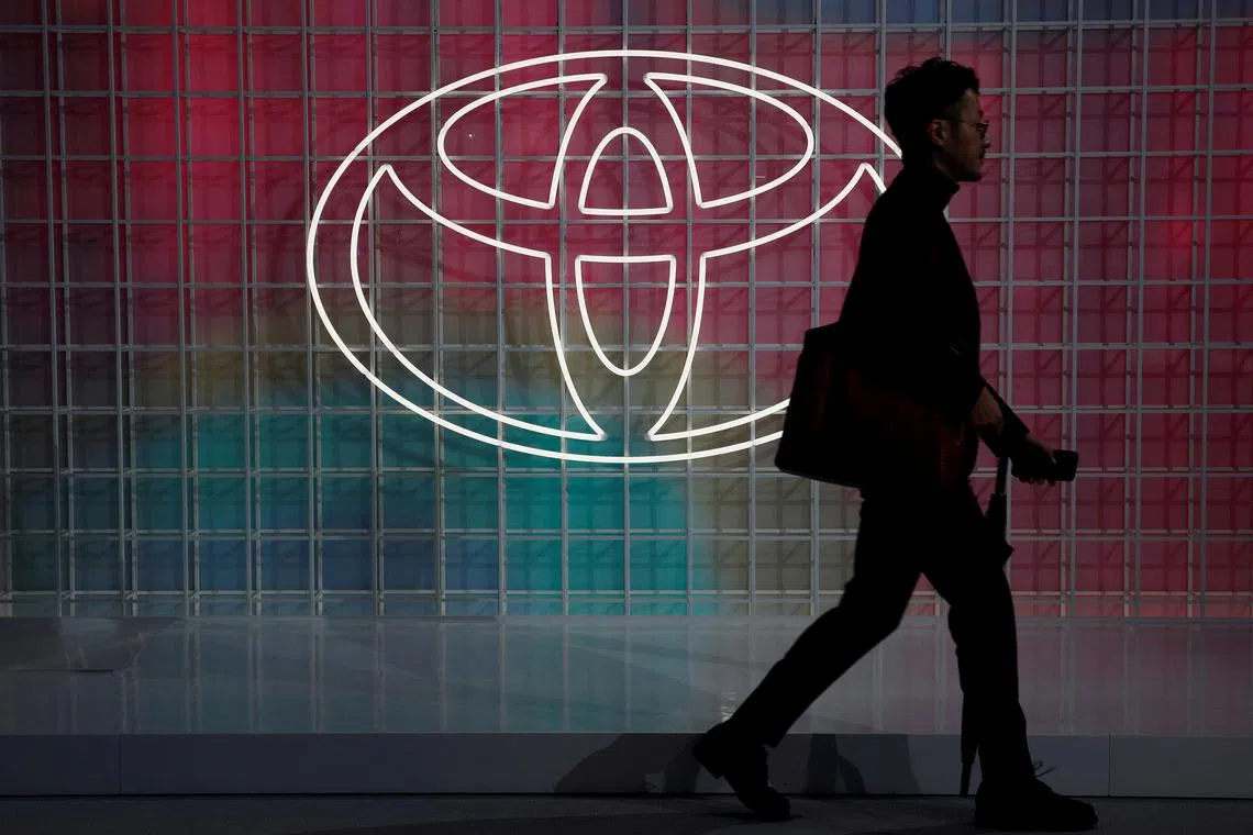 FILE PHOTO: A man walks past a Toyota logo at the Tokyo Motor Show, in Tokyo, Japan October 24, 2019. REUTERS/Edgar Su/File Photo