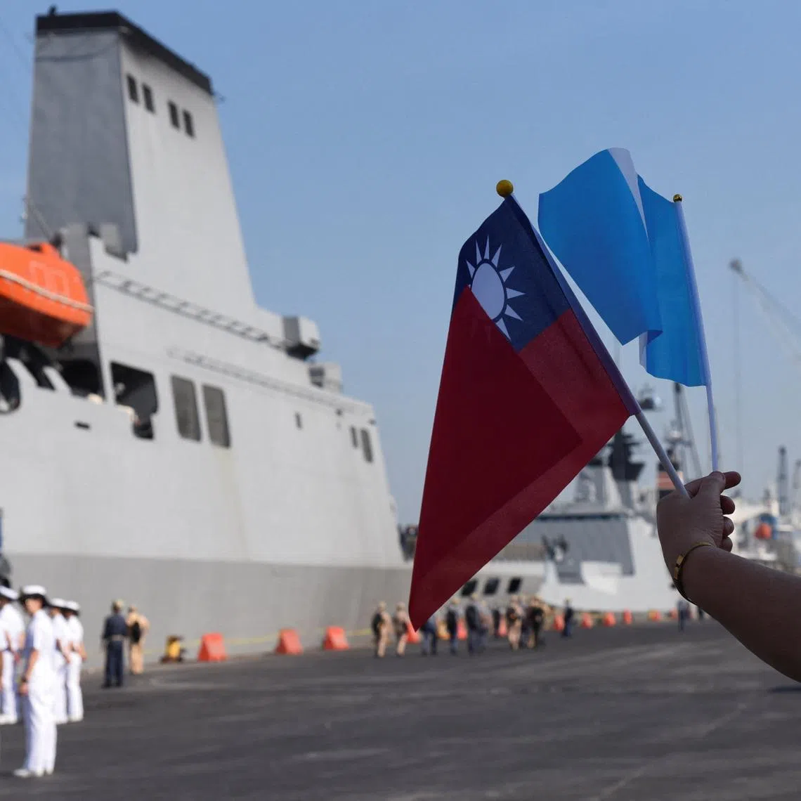 A person holds the Taiwan and Guatemala flags near the flagship warship PAN-SHI (AOE-532), one of three ships in Taiwan's Naval Friendship Squadron, arrives at Puerto Quetzal on a visit to Guatemala as part of its annual cadet training deployment, a goodwill mission aimed at strengthening ties while conducting naval exercises in Central America and the Caribbean, in Puerto Quetzal, San Jose, Escuintla, Guatemala, May 2, 2026. REUTERS/Cristina Chiquin