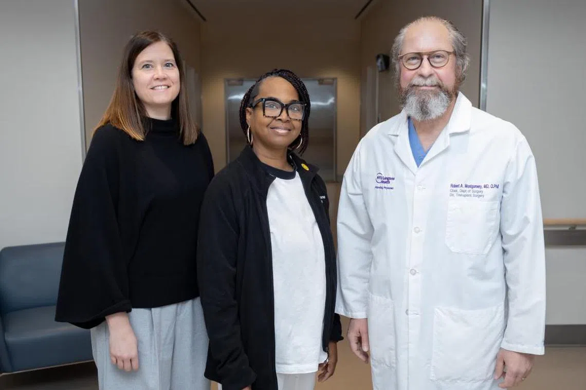 Pig kidney recipient Towana Looney (centre), with transplant surgeons Jayme Locke (left) and Robert Montgomery.
