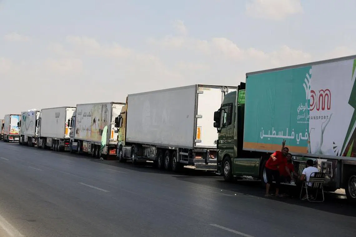 Trucks carrying humanitarian aid to Palestinians, wait on the desert road (Cairo - Ismailia) on their way to the Rafah border crossing to enter Gaza, amid the ongoing conflict between Israel and the Palestinian Islamist group Hamas, in Cairo, Egypt, October 14, 2023. REUTERS/Amr Abdallah Dalsh