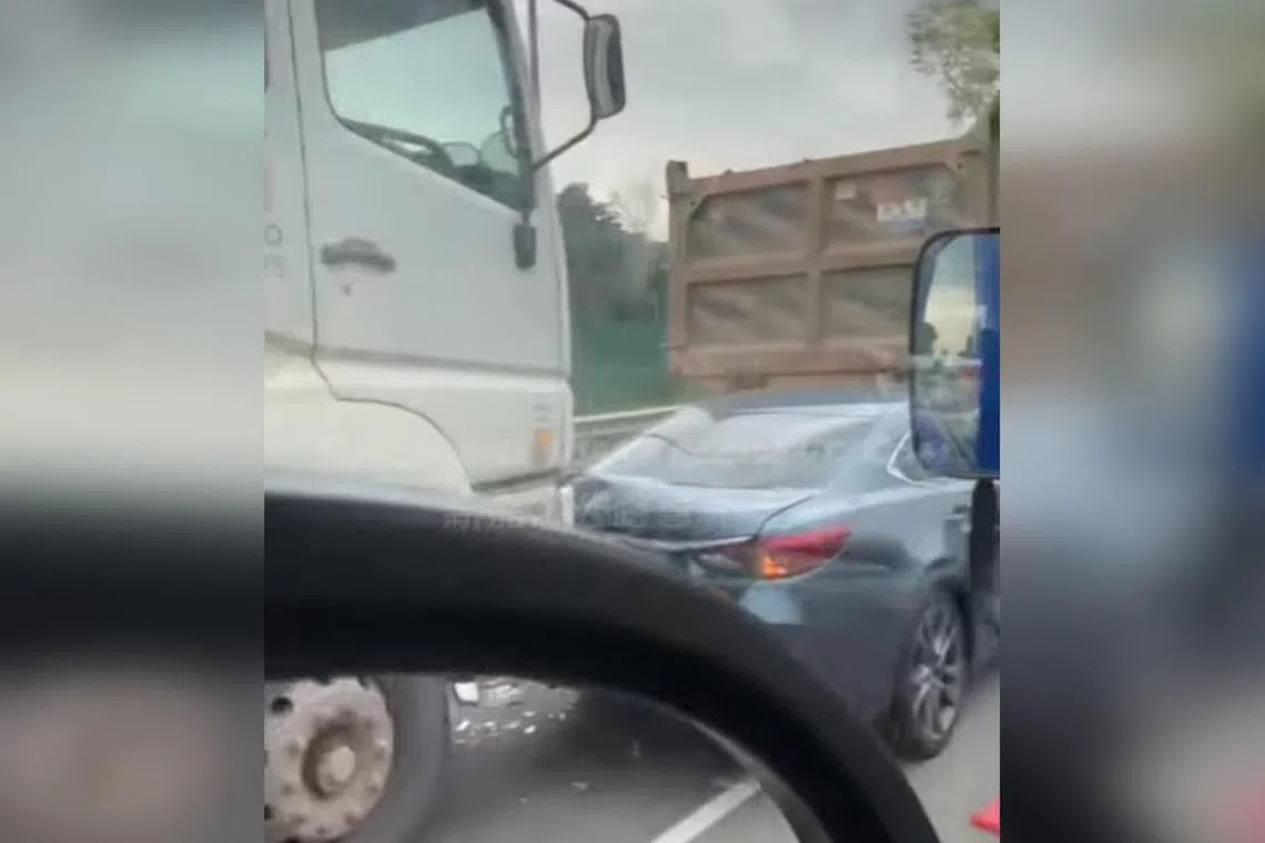 A video posted on Facebook showed a blue car with a damaged rear bumper between two trucks.