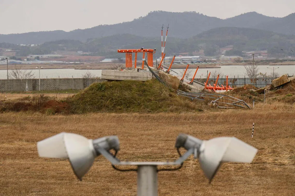 A damaged structure is seen at the end of the runway at Muan International Airport.