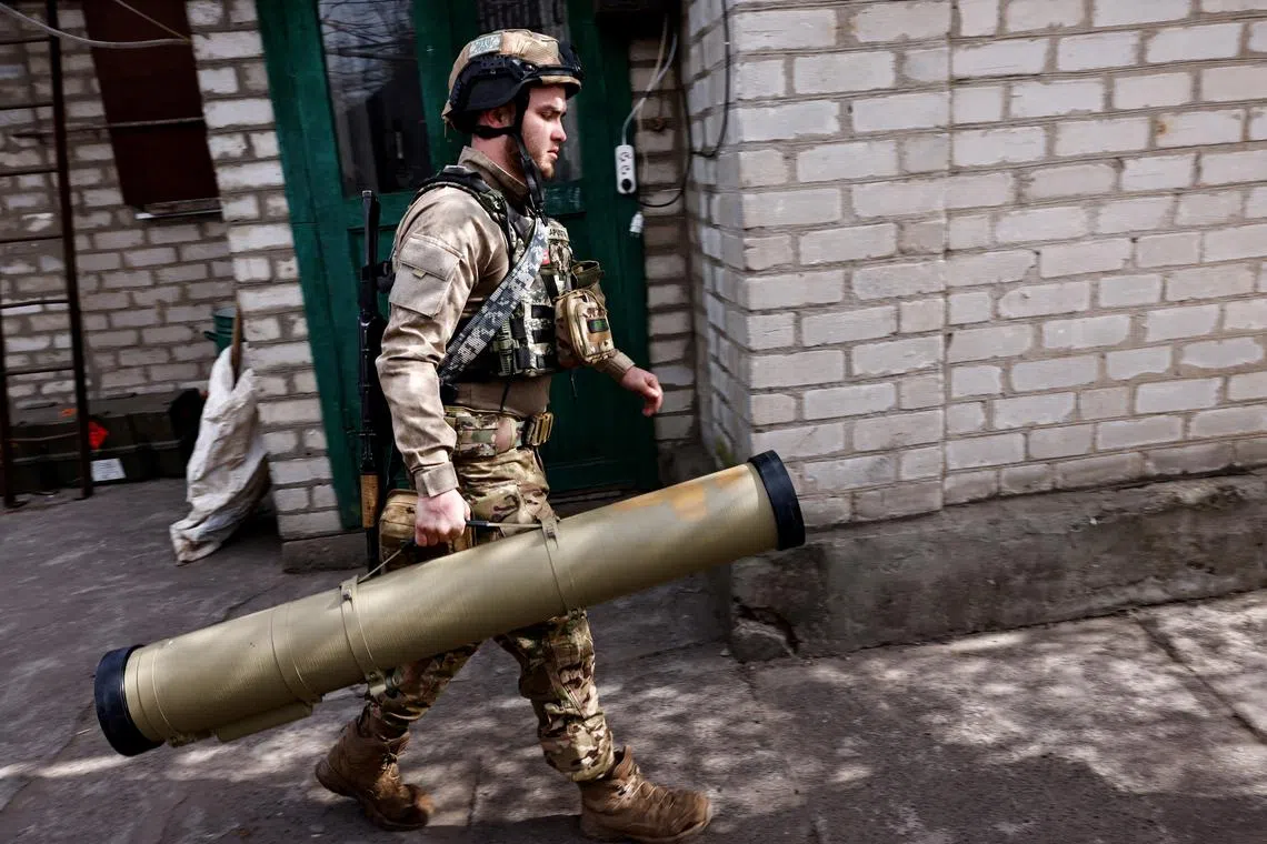 A Ukrainian anti-tank unit soldier carries a Kornet shell to load a guided missile launcher.