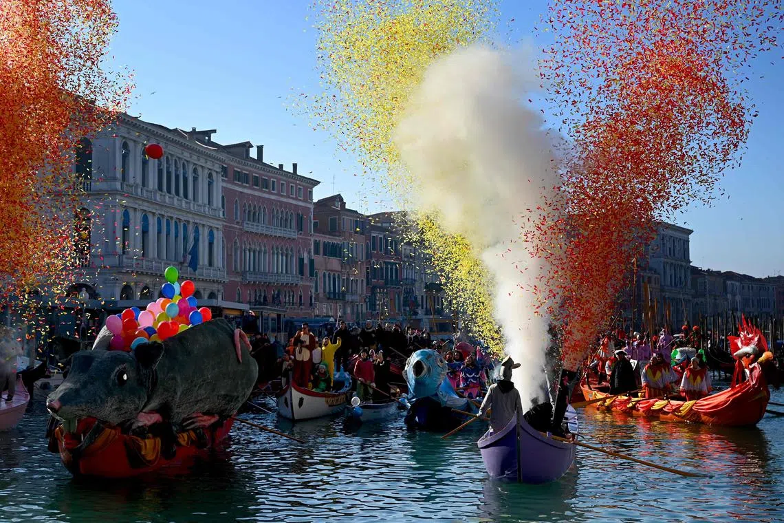 Dressed up revellers sailing their decorated boats across the Grand Canal for the water parade during the Venice carnival on Jan 28, 2024. 