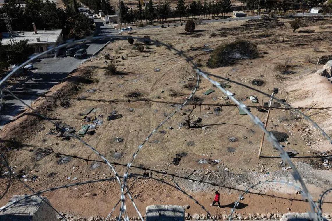A Syrian man walks in front of the prison of Saydnaya, north of Damascus on December 16, 2024. Islamist-led rebels took Damascus in a lightning offensive on December 8, ousting president Bashar al-Assad and ending five decades of Baath rule in Syria. According to the Syrian Observatory for Human Rights, more than 100,000 people died in Syria's jails and detention centres from 2011. (Photo by Sameer Al-DOUMY / AFP)
