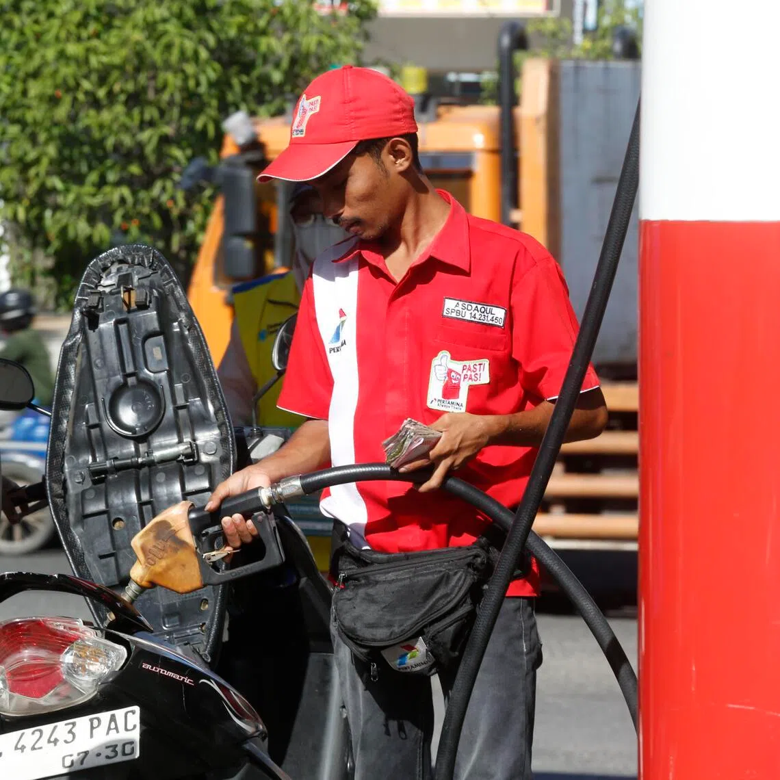 A worker refuels a motorbike at a gas station in Banda Aceh, Indonesia, on April 14, 2026.