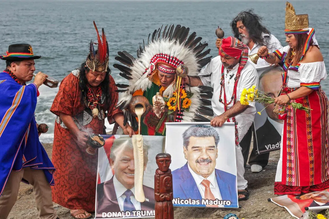 A group of shamans and healers hold images of US President Donald Trump and Venezuelan President Nicolas Maduro while performing end-of-year ritual in front of the sea in Chorrillos, Peru.
