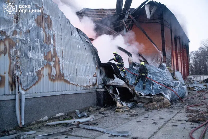 Firefighters work at the site of a warehouse of home appliances which was hit during an overnight Russian drone strike in Odesa, Ukraine on Dec 16.