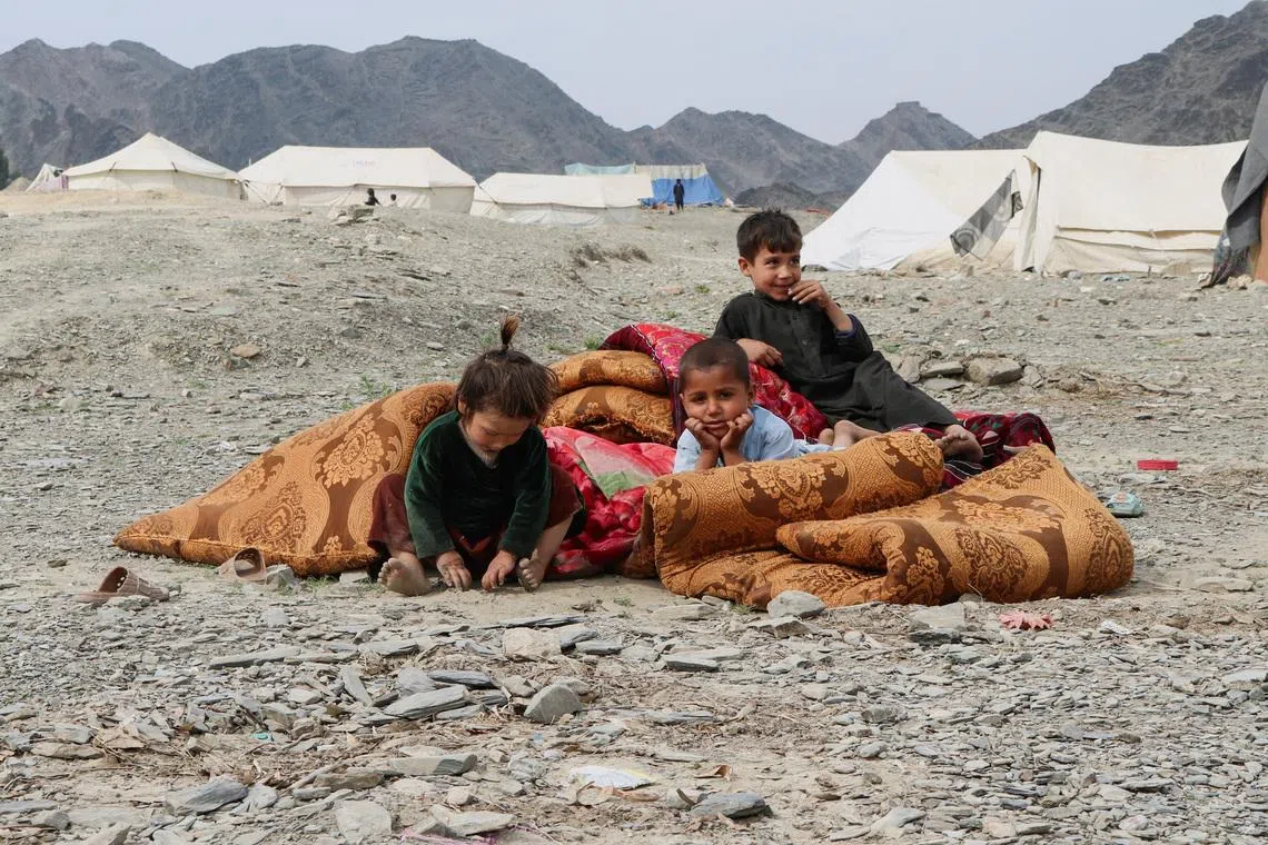 Displaced Afghan children, who along with their family, fled following exchanges of fire between Pakistani and Afghan forces at a border crossing, sit outside their makeshift tent as they take refuge in Lal Pur district in eastern Nangarhar province, Afghanistan, March 4, 2026. REUTERS/Stringer