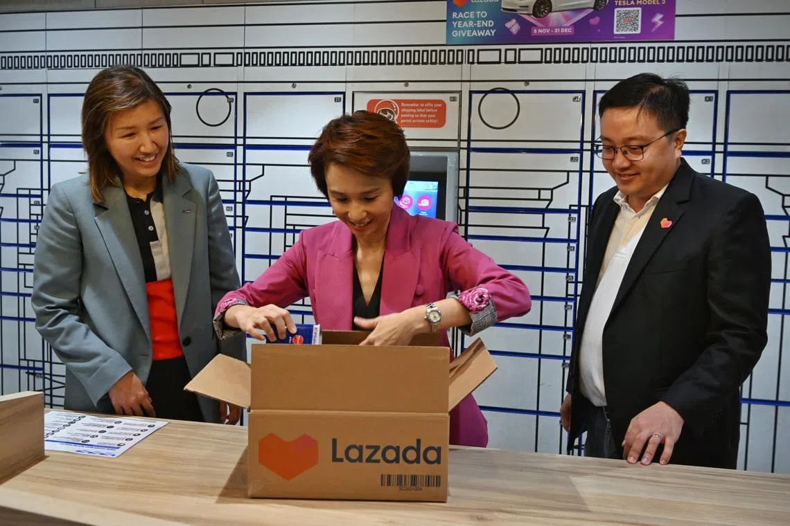 Minister of State for Trade and Industry Low Yen Ling (centre), accompanied by SingPost CEO Neo Su Yin (left) and Lazada Singapore CEO Loh Wee Lee, trying her hand at packaging a parcel.