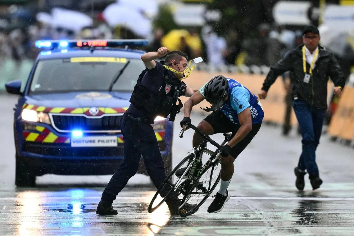 An officer tackling an individual attempting to cycle across the finish line minutes before the final sprint of the 112th edition of the Tour de France cycling race, 160.4 km between Bollene and Valence, southern France, on July 23, 2025. 