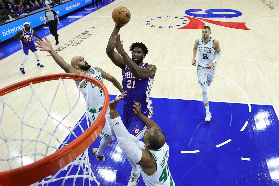 Joel Embiid of the Philadelphia 76ers shoots between Derrick White and Al Horford of the Boston Celtics during the first quarter at the Wells Fargo Centre.
