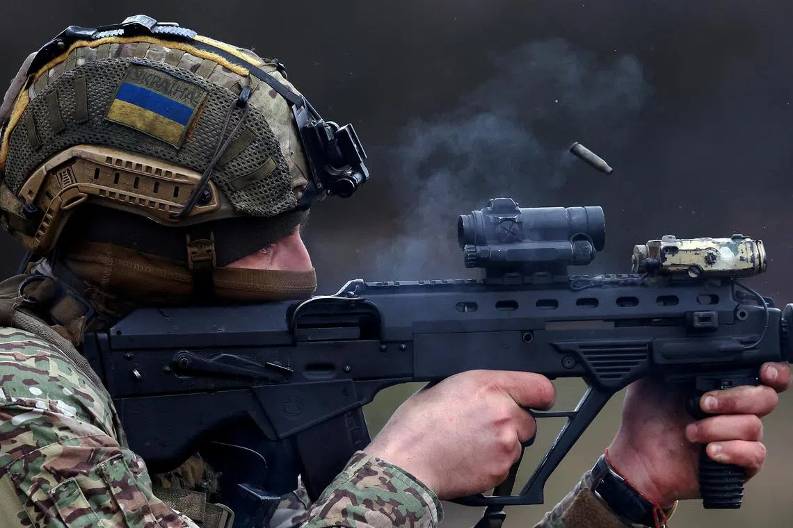 A member of the Ukrainian special force engages in zeroing his weapon prior to a mission, in the region of Bakhmut, Ukraine.